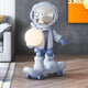 The Giant Sculptures Cosmic Sky Skater Astronaut Glow Sculpture (80cm) in blue and white features an astronaut holding a glowing orb on a skateboard—ideal as striking contemporary décor for modern living rooms with wooden floors.