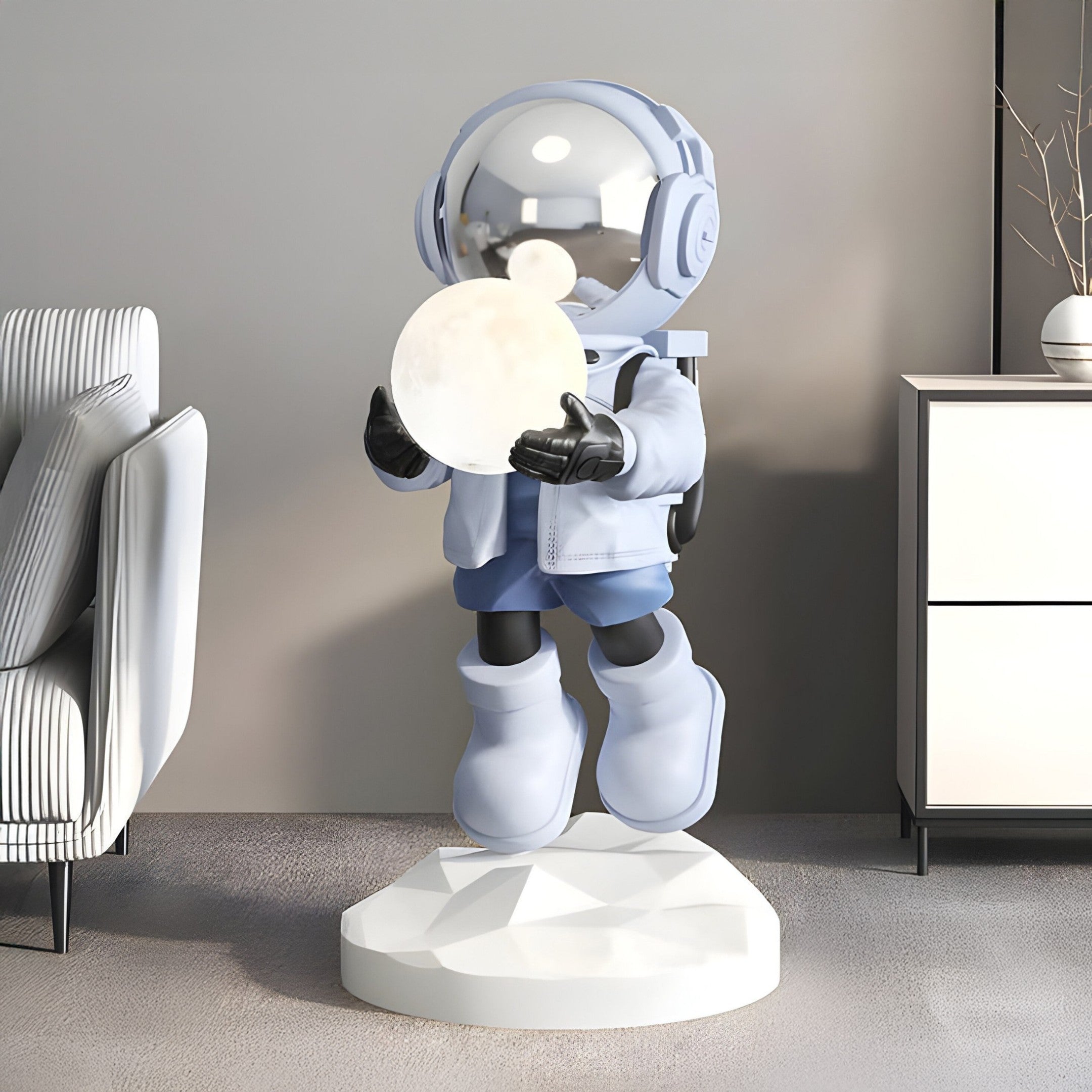 The 80cm Cosmic Sky Astronaut Glow Hover Sculpture by Giant Sculptures features a futuristic astronaut on a geometric base with a glowing sphere, shiny helmet, headphones, space boots, and light jacket with shorts. It pairs well with modern furniture and includes USB charging capabilities.