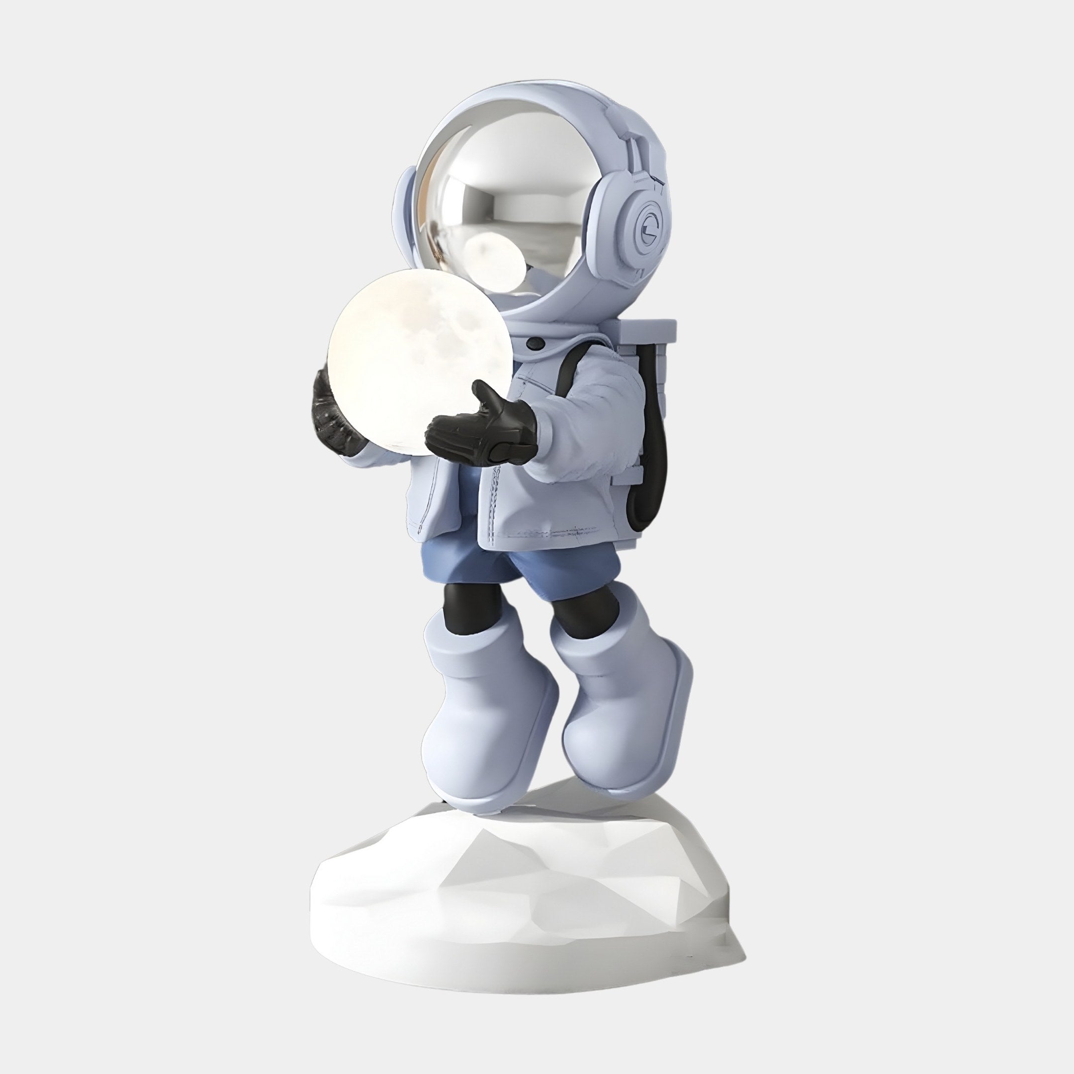 The Cosmic Sky Astronaut Glow Hover Sculpture by Giant Sculptures features a stylized astronaut in a blue space suit with boots, standing on a textured white base. The figure, holding a glowing moon, is topped with a reflective helmet and adds whimsical charm and futuristic flair to any space.