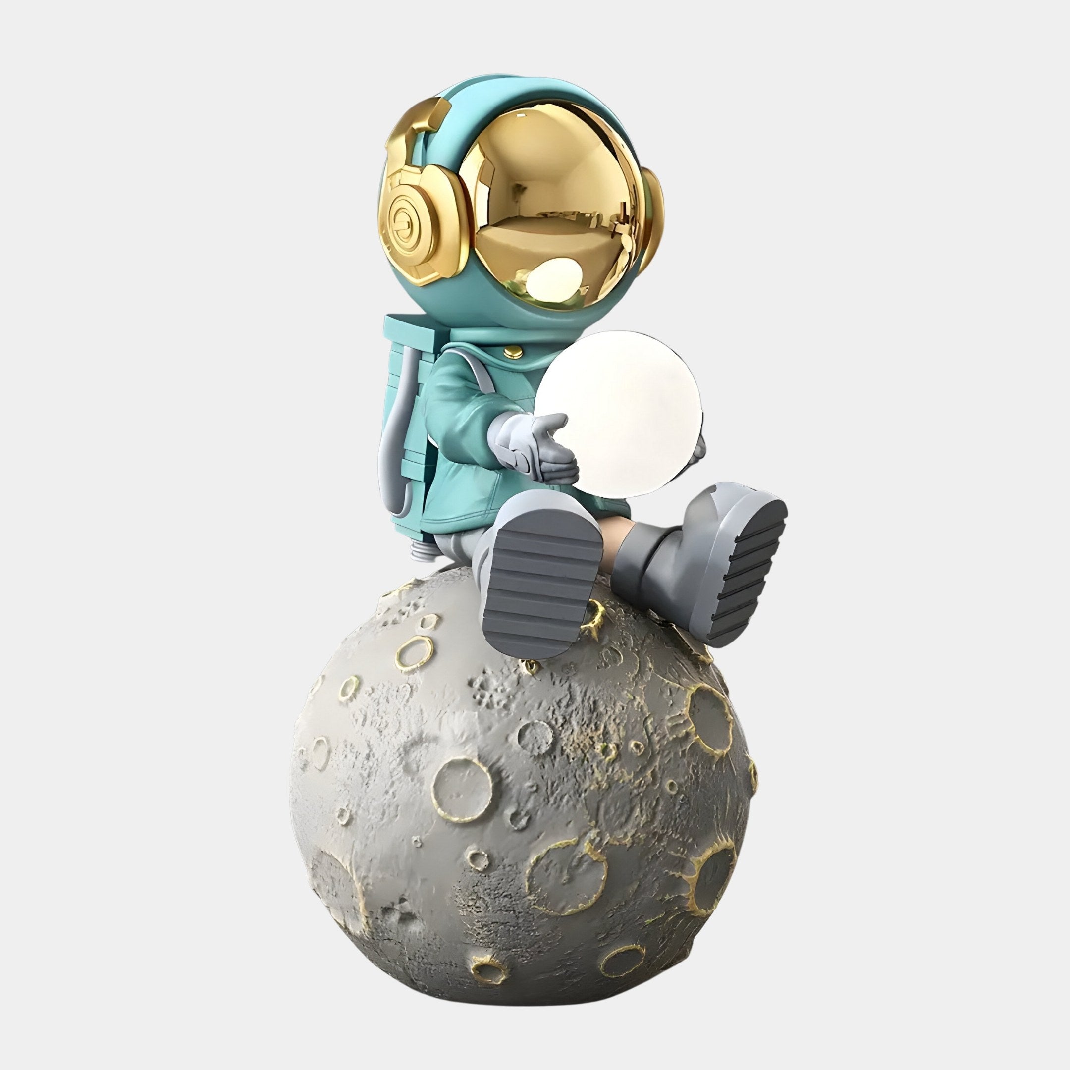 The Galactic Blue Astronaut Glow Moon Sculpture by Giant Sculptures features a whimsical figure in a teal spacesuit with gold headphones and helmet, sitting on a cratered moon while holding an orb, radiating playful charm.