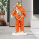 The Solar Orange Space Astronaut Standing Sculpture - 88cm by Giant Sculptures features a gold helmet and white base, creating a bold statement in modern interiors with plants and minimalist accents.