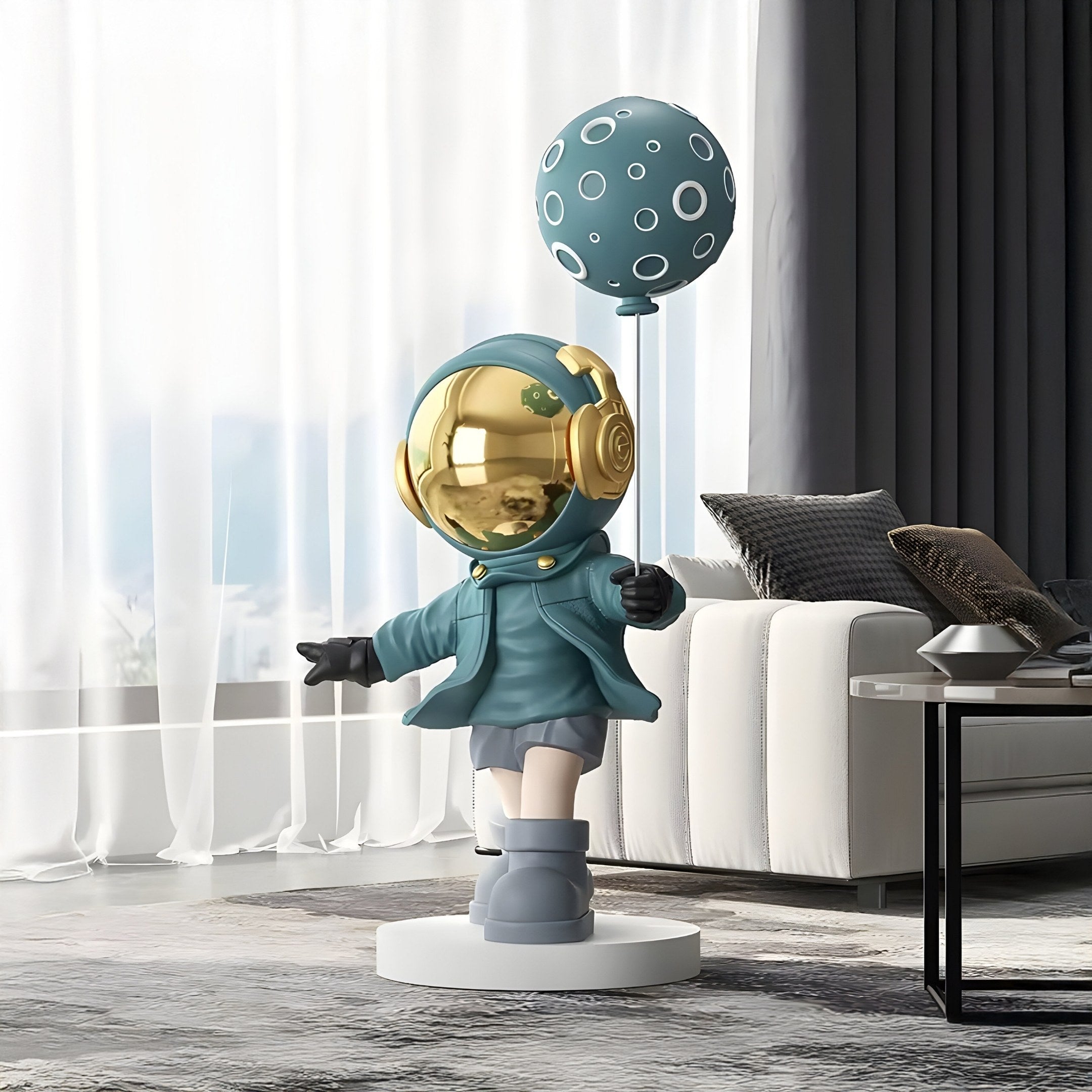 In a modern living room, the 96 cm Galactic Blue Astronaut Moon Balloon Sculpture by Giant Sculptures features a whimsical child in a space suit with a shiny gold helmet and circular patterns, while the couch and curtains subtly enhance the contemporary design backdrop.