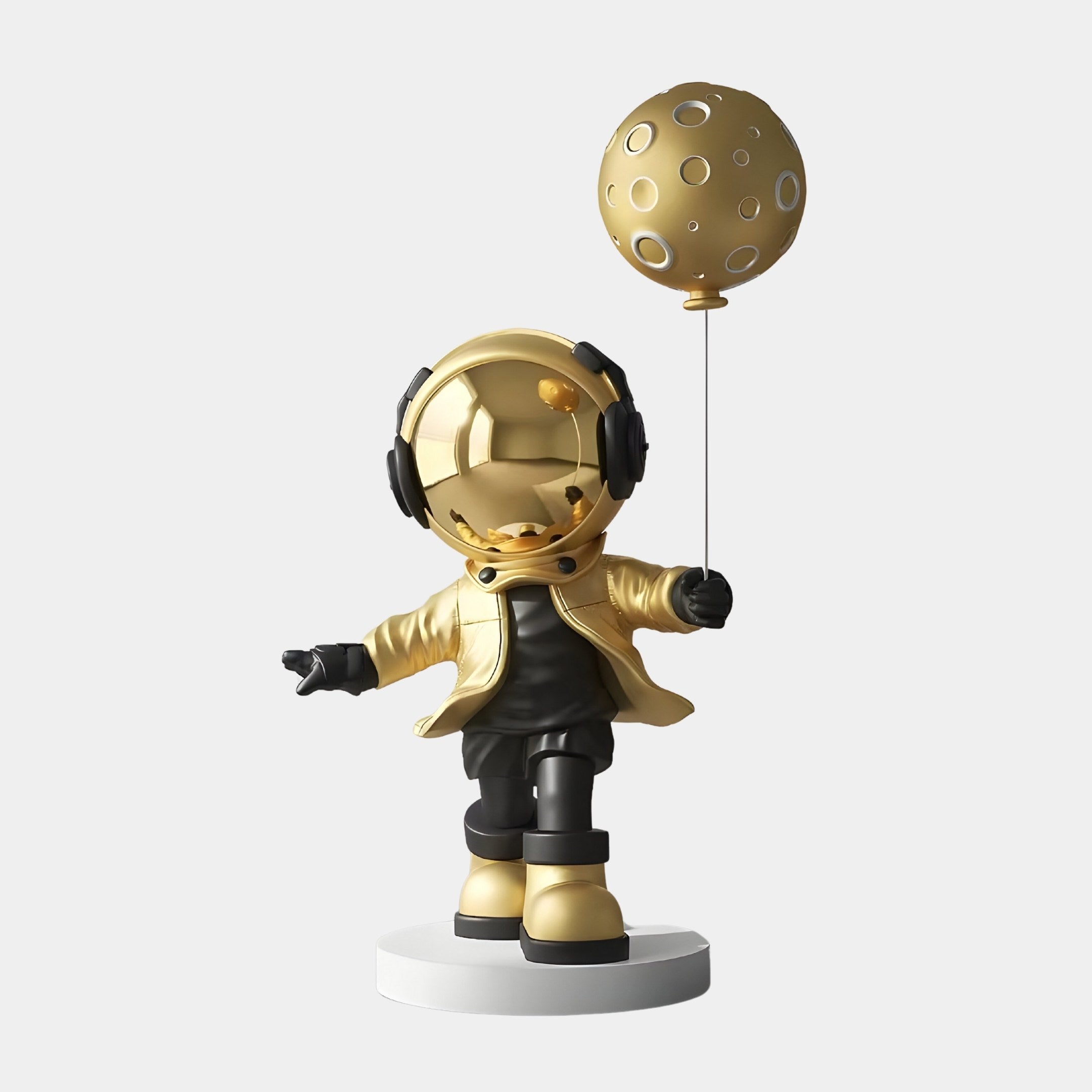 The Celestial Gold Astronaut Moon Balloon Sculpture - 96cm by Giant Sculptures showcases a figurine with a shiny helmet and matching jacket, holding a gold moon-shaped balloon. It stands on a round white base with outstretched arms, embodying Cosmic Elegance against a plain background.