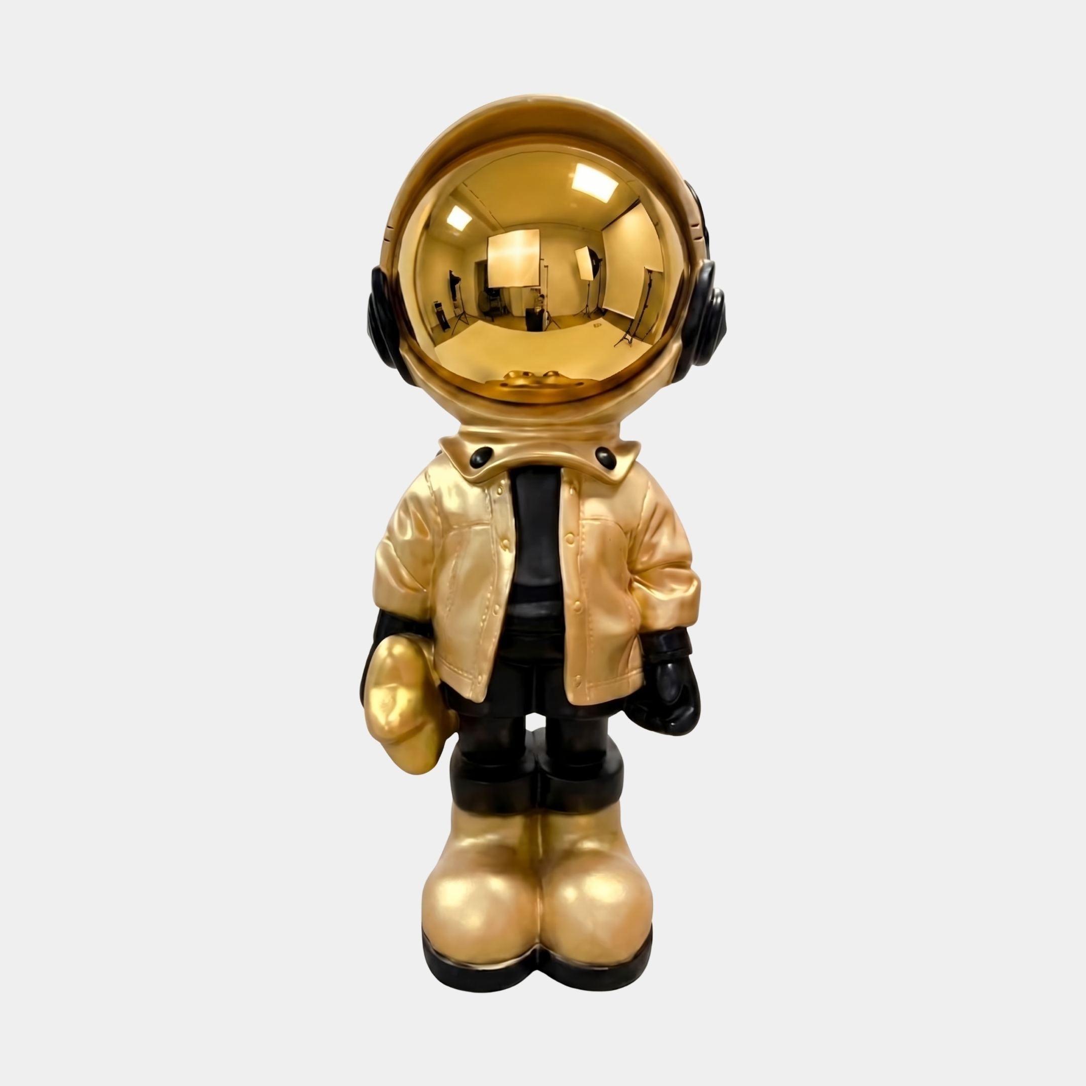Celestial Gold Astronaut Beats Sculpture by Giant Sculptures, 70cm resin figure with mirrored gold helmet, gold jacket, black headphones, gloves and boots.