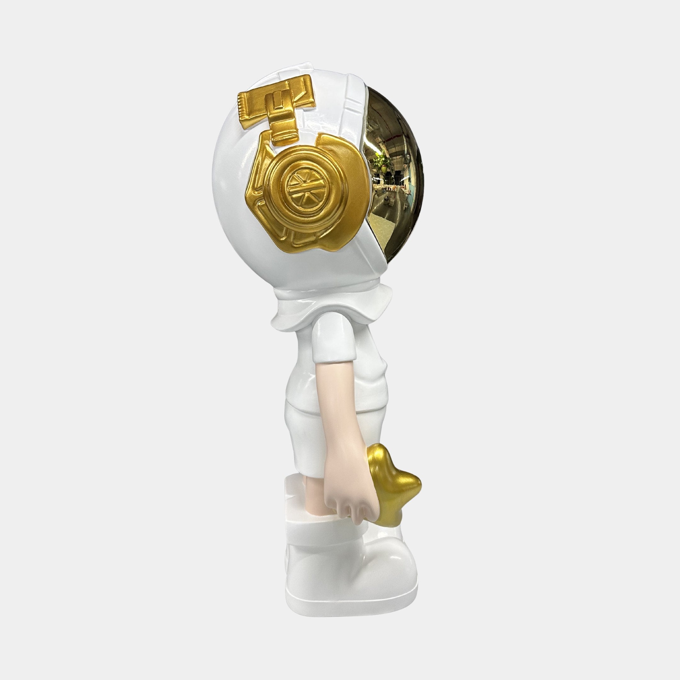The Cosmic White Astronaut Buddy Sculpture (70cm) by Giant Sculptures features a stylized figure in a white suit with gold accents, holding a small gold star—ideal as modern home décor.