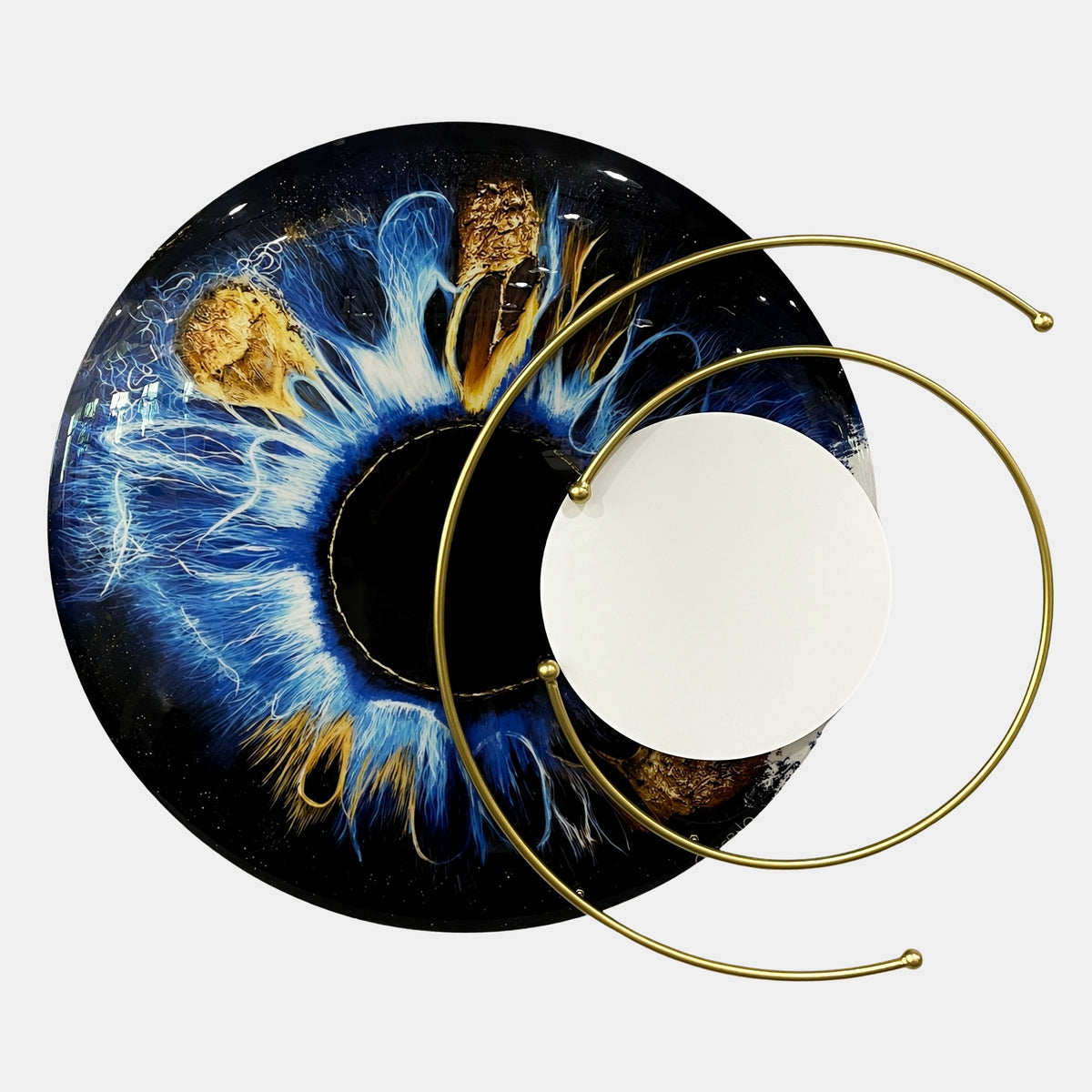 Aurelios Cosmic Blue Crystal Porcelain & Gold Orbit 3D Wall Art featuring a circular iris design in blue and gold with a white mirrored disc and orbiting gold metal rings, shown on a plain white background.
