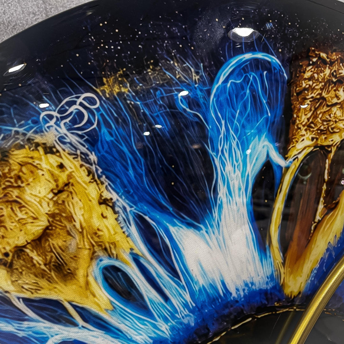 Close-up of the Aurelios Cosmic Blue Crystal Porcelain & Gold Orbit 3D Wall Art, showing deep blue crackling patterns and gold textured accents on a starry dark background.