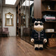 Black Couture Bear Sculpture, 70cm, in sunglasses, pearl necklace, sequined skirt and bouclé jacket, displayed in a wardrobe room with wooden shelving and books.