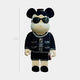 The Black Couture Bear Sculpture - 70cm by Giant Sculptures features round ears, a neutral expression, black sunglasses, a pearl necklace, bouclé jacket, black sequined skirt, and carries a small pink handbag.
