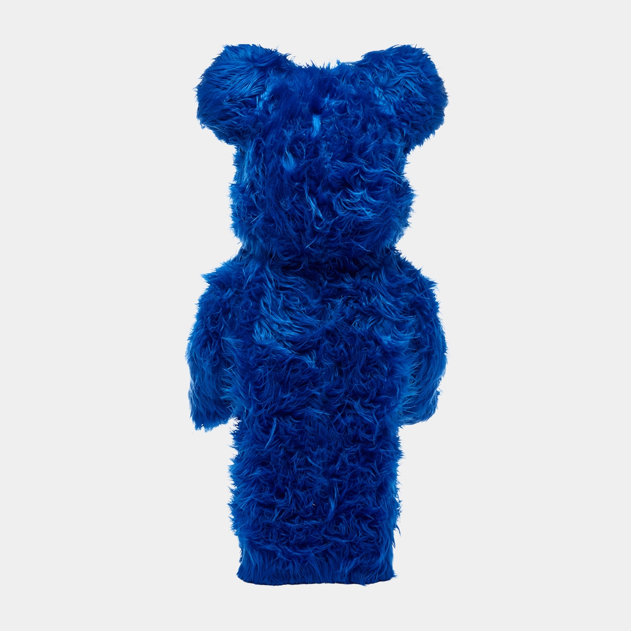 The Blue Fuzzy Bear Sculpture by Giant Sculptures stands upright at 70cm, displaying its cobalt-blue fur and bear-like form from behind against a plain white background.