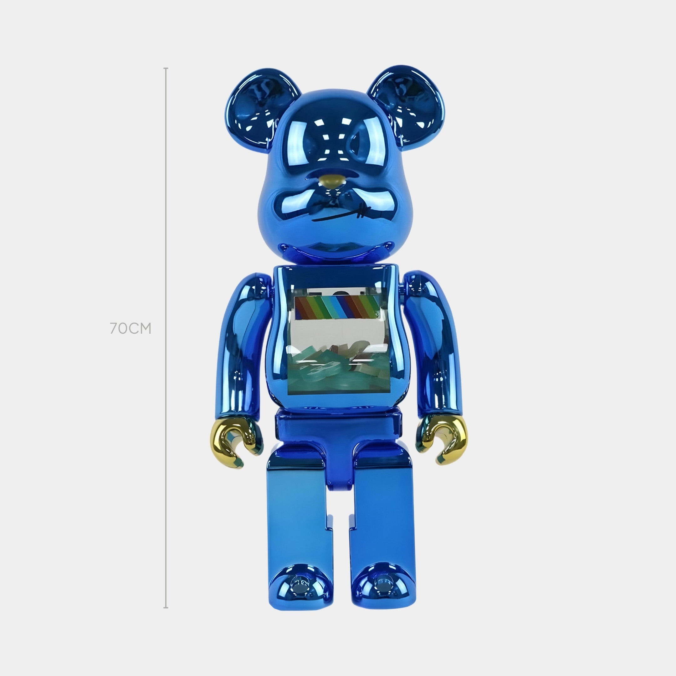 The Giant Sculptures Spectrum Blue Bear Sculpture - 70cm stands upright, featuring a colorful chest image and reflective ears and paws that display chromatic brilliance, all set against a plain white background.