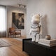 Bolt Collar White Bear Sculpture, 70cm, with black lightning bolt collar graphic, displayed on a dark sideboard in a living room with books, a vase, and abstract wall art.
