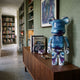Brushstroke Horizon Bear Sculpture, 70cm, in blue and purple high-gloss resin, displayed on a walnut sideboard in a library hallway.