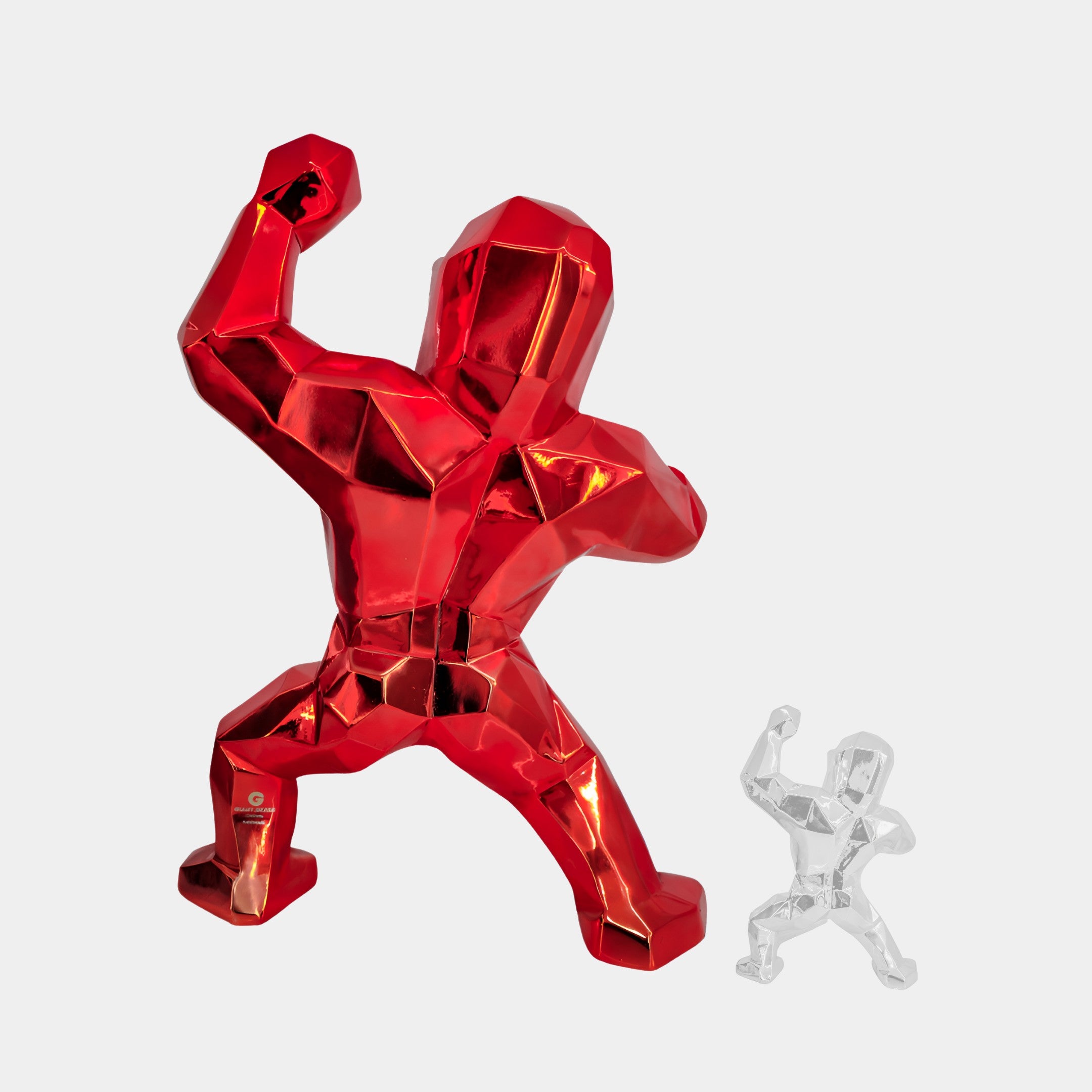 The contemporary interior features two geometric sculptures of muscular figures in a victory pose: the larger Fire Red Gorilla Sculpture - 165cm by Giant Sculptures and a smaller clear piece, both with angular, block-like shapes on a plain white background, ideal for indoor displays.