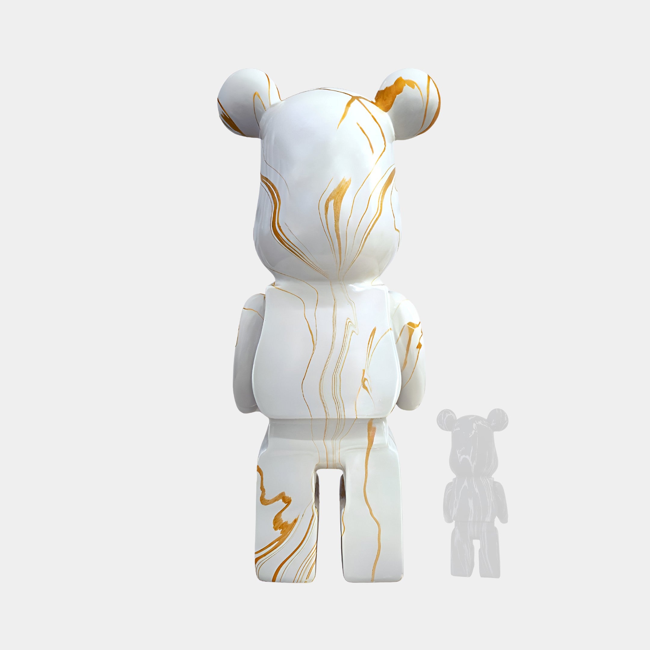 The rear view of this bear sculpture showcases the continuous flow of golden streaks cascading down its back. The seamless blend of white and gold adds a sense of luxury, with the smooth finish reflecting light beautifully. Its height, standing at 165cm, is emphasized against the background.