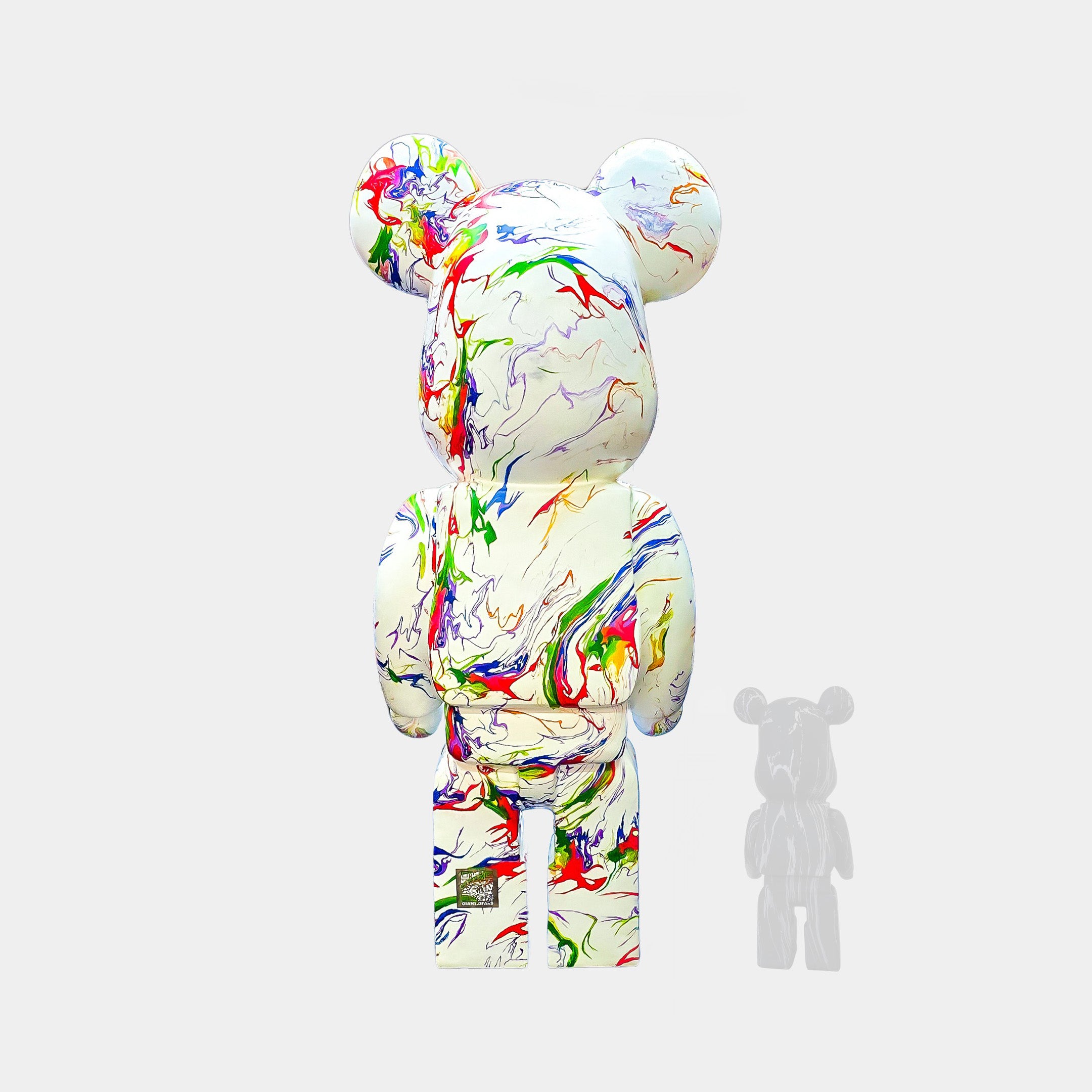 A Vogue Bear Sculpture by Giant Sculptures, featuring a 165cm bear with colorful marble-like swirls, stands against a plain background. A smaller shadow-like version accompanies this stylish piece of contemporary decor on the right.