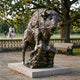 Monumental Traditional Bison Bronze Sculpture, 230cm, cast bronze bison climbing a rocky outcrop on a stone base, set in a park with a bench and trees behind.
