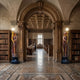 Monumental Classical Goddess Lamp Bearer Bronze Sculpture, 230cm, flanking a library archway on dark pedestals with gilt torch arms and glowing globe lamps.
