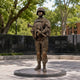 Life-Size Contemporary Female Soldier Bronze Statue by Giant Sculptures, 210cm mid-brown patina figure in combat kit holding a rifle, on a memorial plaza.