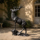 Large Traditional Rearing Stag Bronze Sculpture by Giant Sculptures shown in a gravel courtyard, dark patina stag with raised head and antlers on rocky base.
