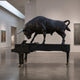 Monumental Contemporary Charging Bull on Grand Piano bronze sculpture by Giant Sculptures, matte black patina, displayed in a gallery with paintings.