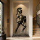 Life-Size Classical Greek Warrior Bronze Statue by Giant Sculptures displayed in a wall alcove of a modern entryway beside a wooden staircase and tall window.