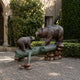 Large Traditional Bear and Cub Bronze Sculpture by Giant Sculptures, showing an adult bear and cub facing across a verdigris log on river stones in a garden.
