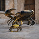 Monumental Contemporary Crab and Companion Bronze Sculpture by Giant Sculptures, showing a large dark bronze crab with raised claws beside a smaller golden crab on stone paving.