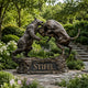 Monumental Bull and Bear Bronze Sculpture by Giant Sculptures, dark antique patina, bear and bull clashing on a rocky base with engraved Stifel plinth in a garden.