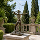 Classical Nude Male Archer Bronze Sculpture, 120cm, drawing a bow on a stone plinth on an outdoor terrace with balustrades and trees behind.
