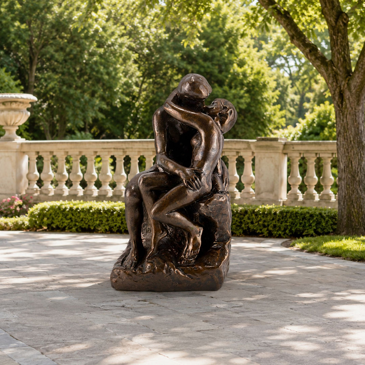 Large Classical Embracing Figures Bronze Sculpture, 180cm, two nude figures in an embrace on a rough base, set on a stone patio near a garden balustrade.