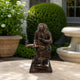 Traditional Reading Monkey Bronze Sculpture, 60cm, seated on stacked books holding an open volume, dark bronze finish, displayed outdoors on a stone table.