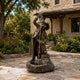 Large Traditional Drinking Cowboy Bronze Sculpture, 190cm, cast bronze figure pouring water from a jug, set on rock base fountain in a stone courtyard garden.