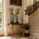 Classical Paired Goddess Candelabra Bronze Sculpture, 80cm, teal patina figures with gold detail on gilt console table beneath staircase in an entryway.