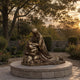 Monumental Classical Kneeling Christ in Prayer Bronze Sculpture, 250cm, kneeling robed figure with hands on rock formation, set on a stone platform in a garden at dusk.