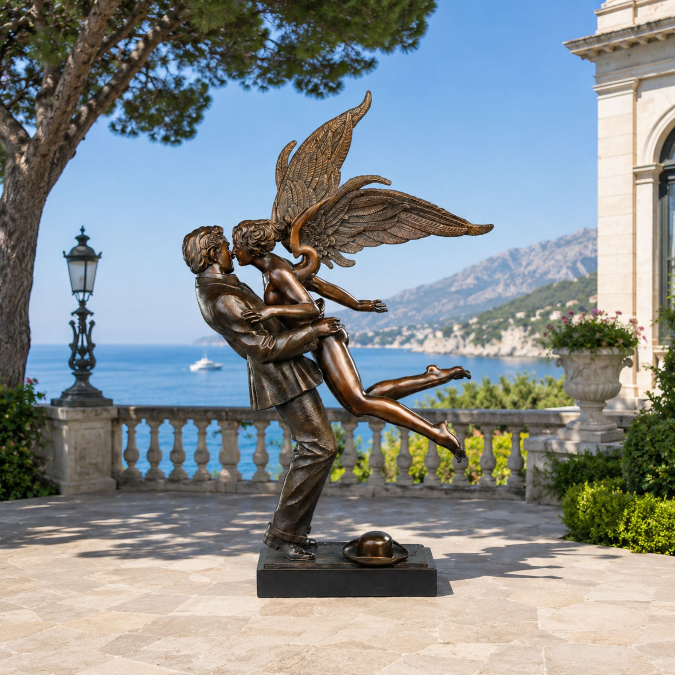 Large Classical Angel and Male Figure Bronze Sculpture, 210cm, on a terrace overlooking the sea, man embracing winged angel with a hat resting at his feet.