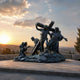 Monumental Classical Christ Carrying the Cross Bronze Sculpture, 300cm, four-figure scene on a rocky base, outdoors at sunset with hills in the background.