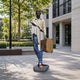 Life-Size Contemporary Fragmentary Traveller Bronze Sculpture, 210cm, painted bronze figure with floating head and torso gap, holding a suitcase, outdoor plaza setting.