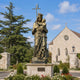 Monumental Classical Virgin Mary and Infant Jesus Bronze Statue, 400cm, crowned figure holding a cross staff with child, dragon underfoot, on stone pedestal outside a church.