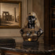 Classical Egyptian Queen Bust Bronze Bust with Nemes headdress, 80cm, black-brown patina with gold accents, displayed on a marble console table beside books and framed Egyptian art.