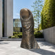 Monumental Contemporary Oversized Human Thumb Bronze Sculpture, 250cm, upright textured bronze thumb outdoors near bamboo and glass building facade.