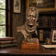 Traditional Man with Neckerchief Bronze Bust, 65cm, on a wooden base atop a study desk with bookshelves and framed art in the background.