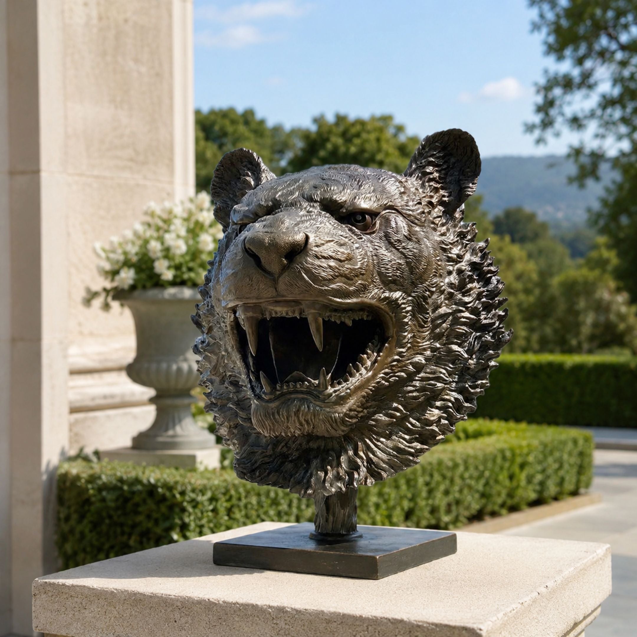 Contemporary Roaring Tiger Head Bronze Bust, 45cm, on a stone pedestal outdoors with gardens and hills in the background.
