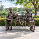 Life-Size Traditional Grandparents and Grandchildren on Bench Bronze Sculpture, 250cm, bronze figures on a bench in a park setting with trees and a lake.