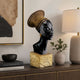 Contemporary African Female Bust Bronze Sculpture, 70cm, black finish with gold coiled headwrap on a gold textured base, shown on a console table beside a lamp and framed art.