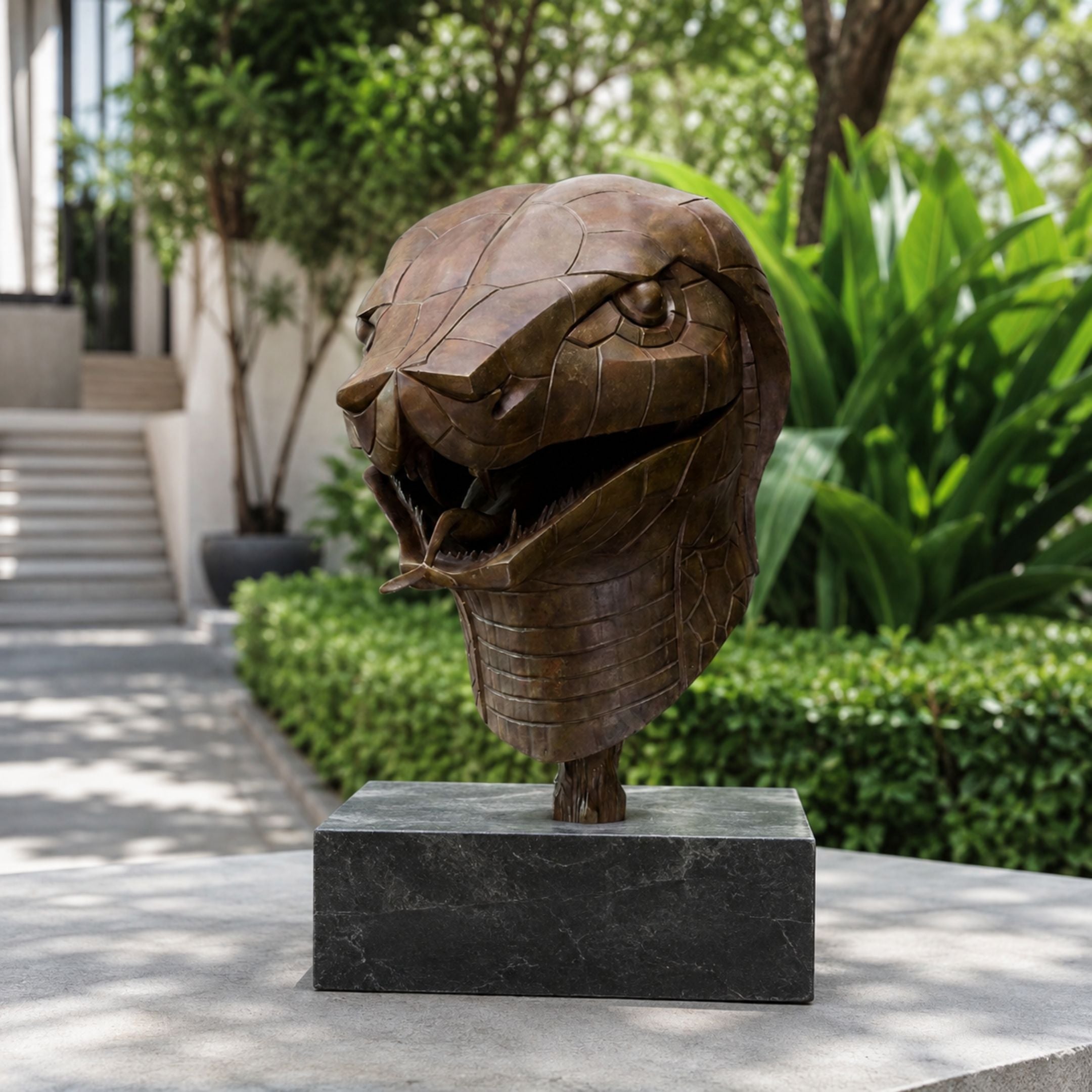 Contemporary Geometric Cobra Head Bronze Sculpture, 45cm, faceted bronze finish with open jaws on a dark stone base, shown outdoors near greenery.