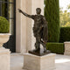 Life-Size Classical Roman Commander Bronze Statue, 150cm, on stone base outdoors, arm raised pointing, near columned entrance and greenery.