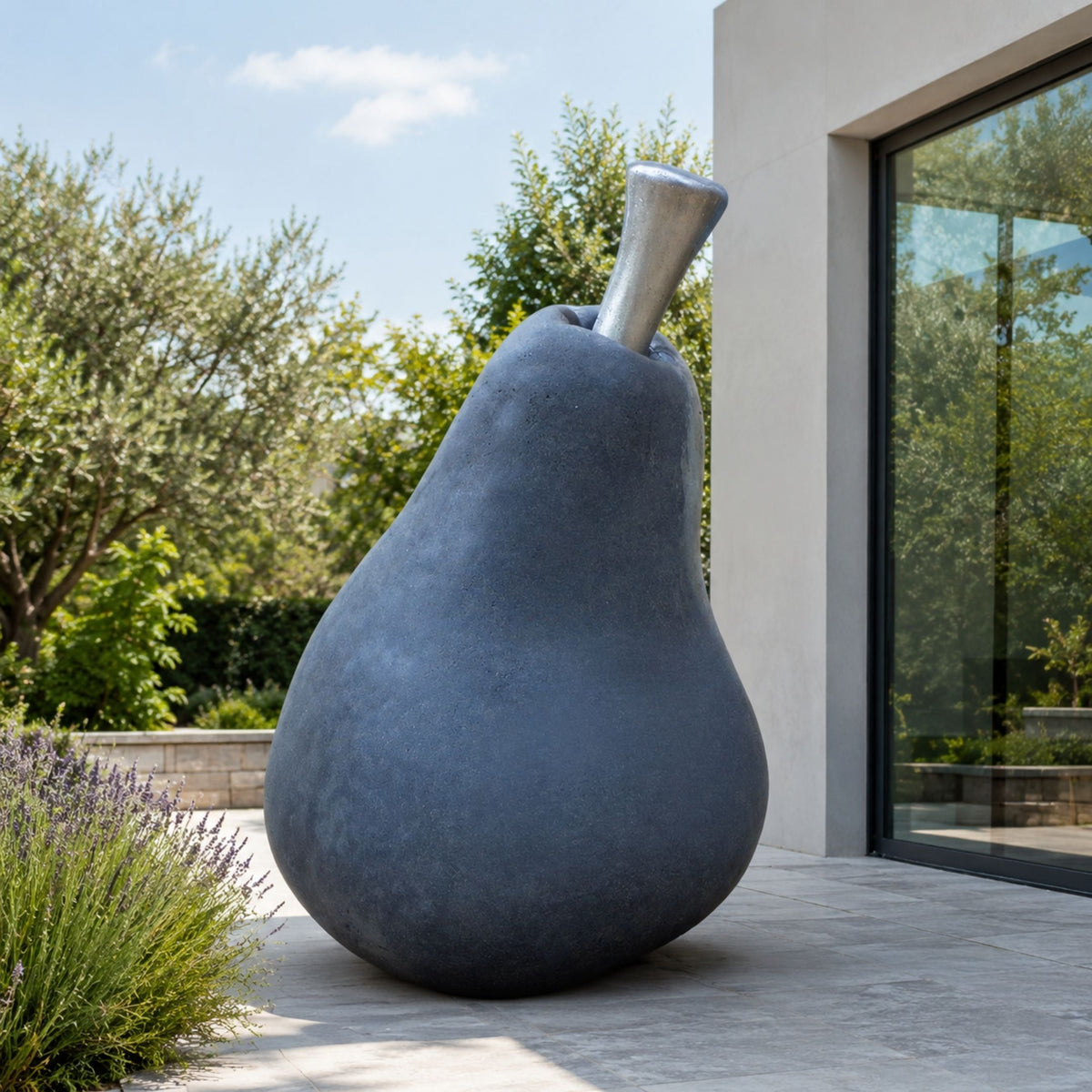 Monumental Contemporary Pear Fruit Bronze Sculpture - 220cm, dark patinated finish with metallic stem, displayed on a patio beside lavender and a modern glass-walled building.