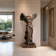 Monumental Classical Winged Goddess Bronze Sculpture, 210cm, headless winged figure in flowing robes on a stone base, shown against a hallway wall near a living room.