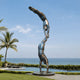 Monumental Contemporary Acrobatic Figures Bronze Sculpture, 800cm, showing two balanced acrobats in patinated bronze on a round plinth beside a poolside seaside garden.